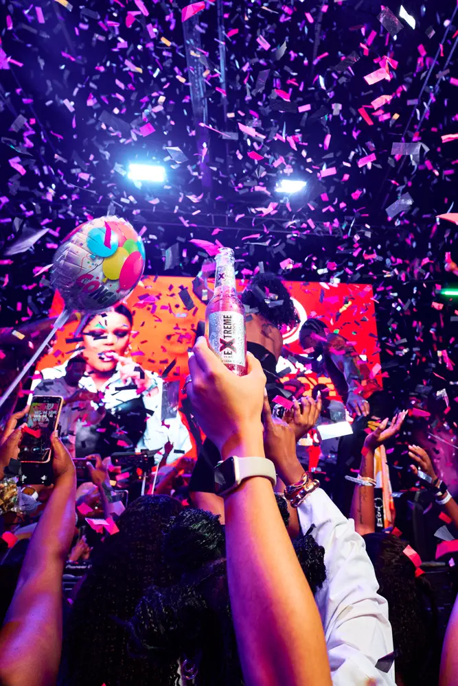 Confetti mid-air over the crowd, an Extreme can raised, on the final beat