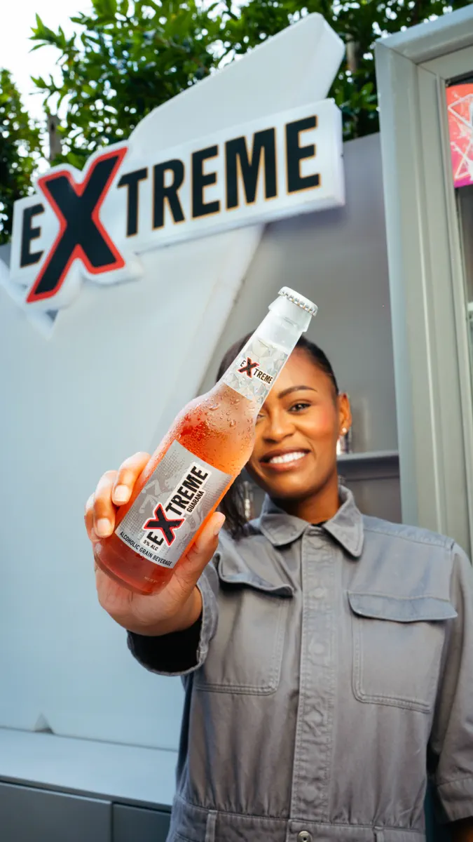 Extreme crew member with the product in front of the giant EXTREME sign